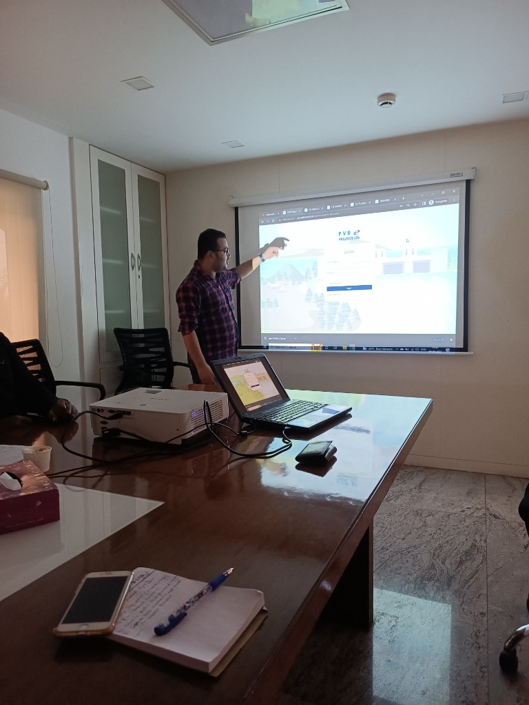 Naffys Mir presenting a client web application on a projector in a conference room.